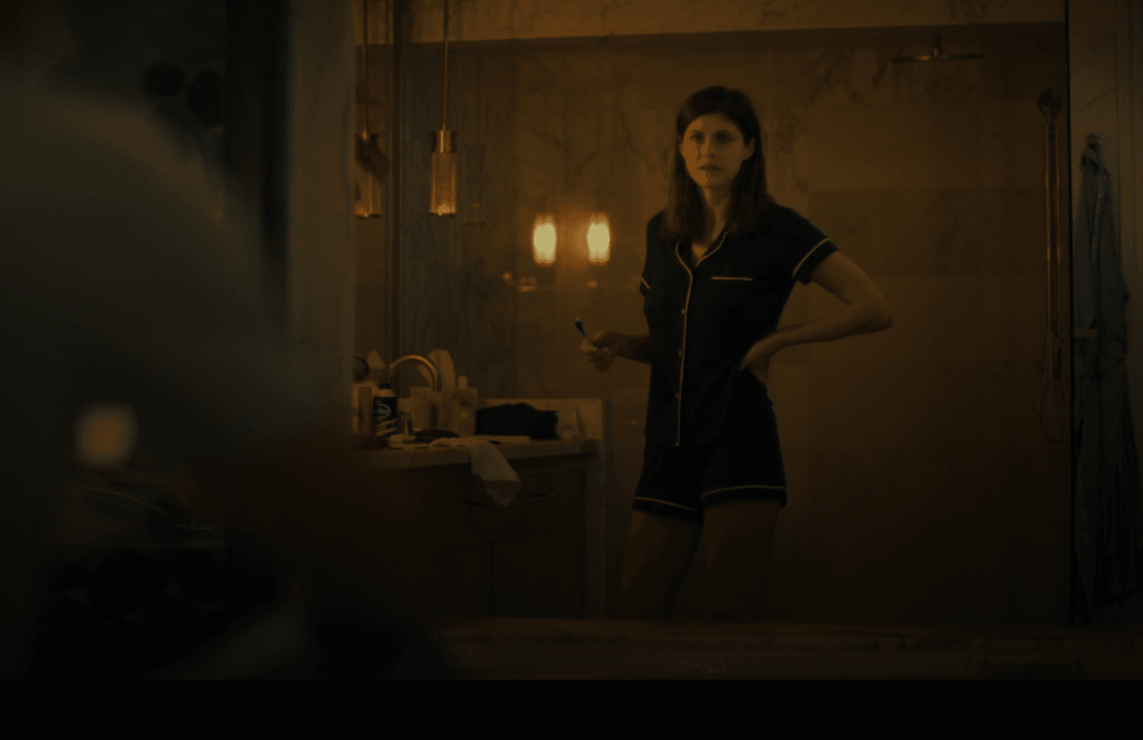 Rachel Patton embodies relaxed elegance in a classic short-sleeved pajama set, captured in a private moment within a luxurious bathroom setting.